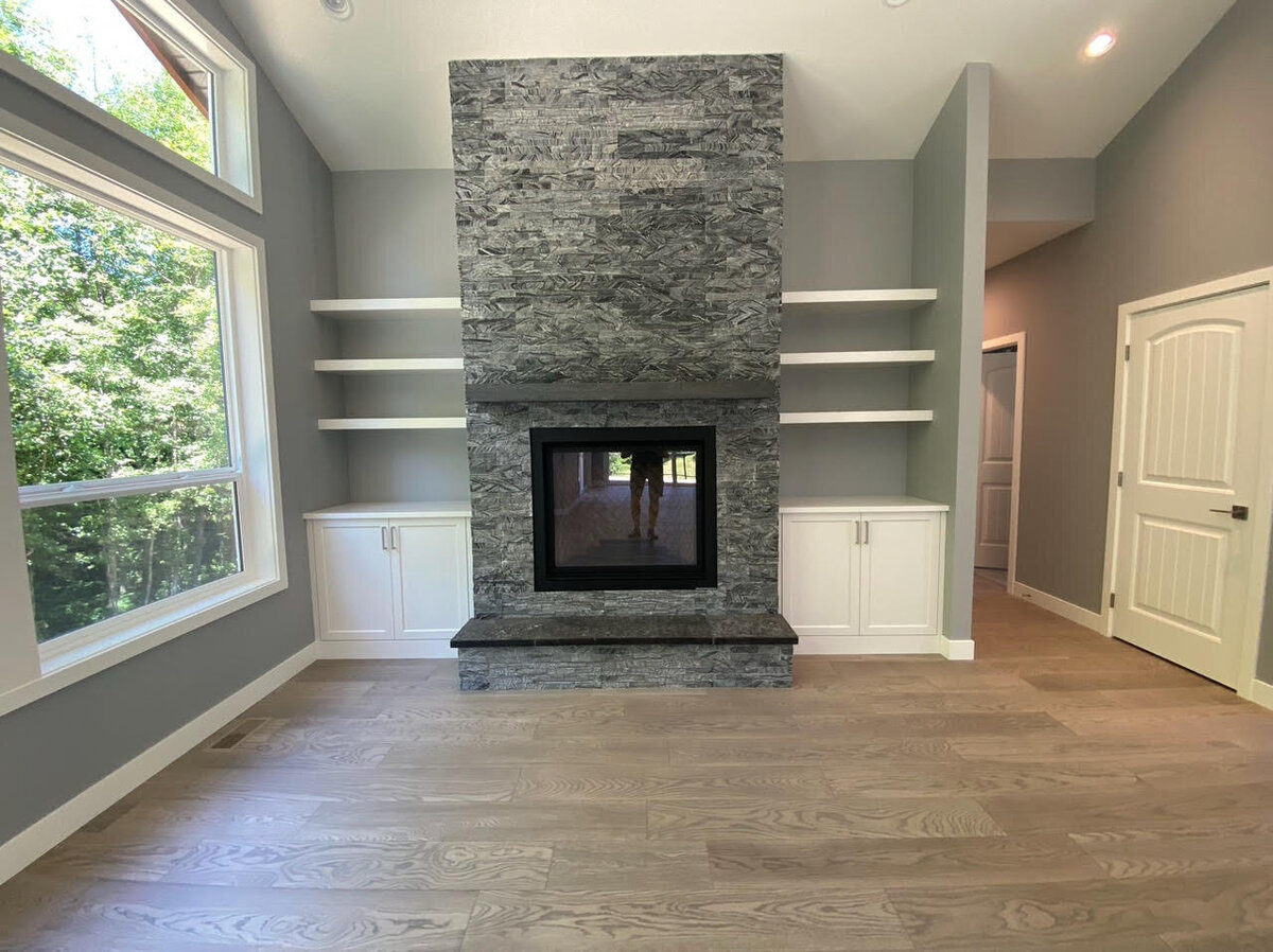 Floor to ceiling stone fireplace with built in  shelves and bookcases.