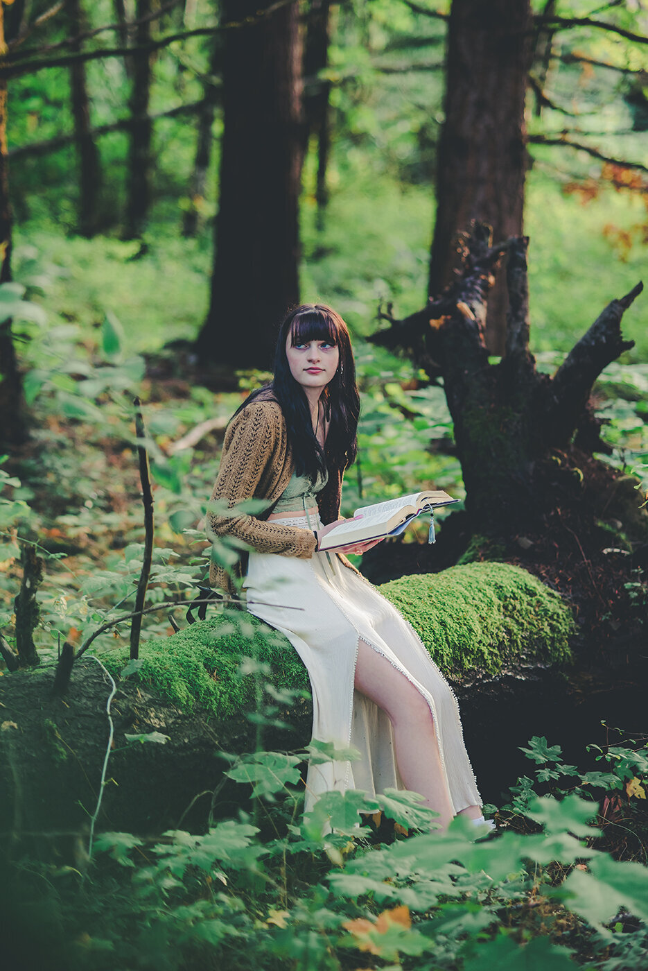 senior girl reading on log