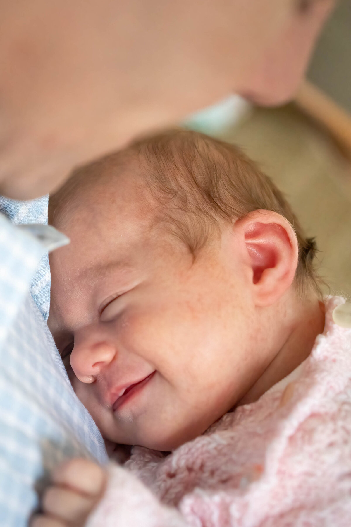 Baby girl sleeping and smiling in dad's arms