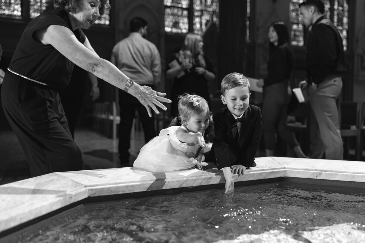 Woman trying to stop young children from playing in holy water