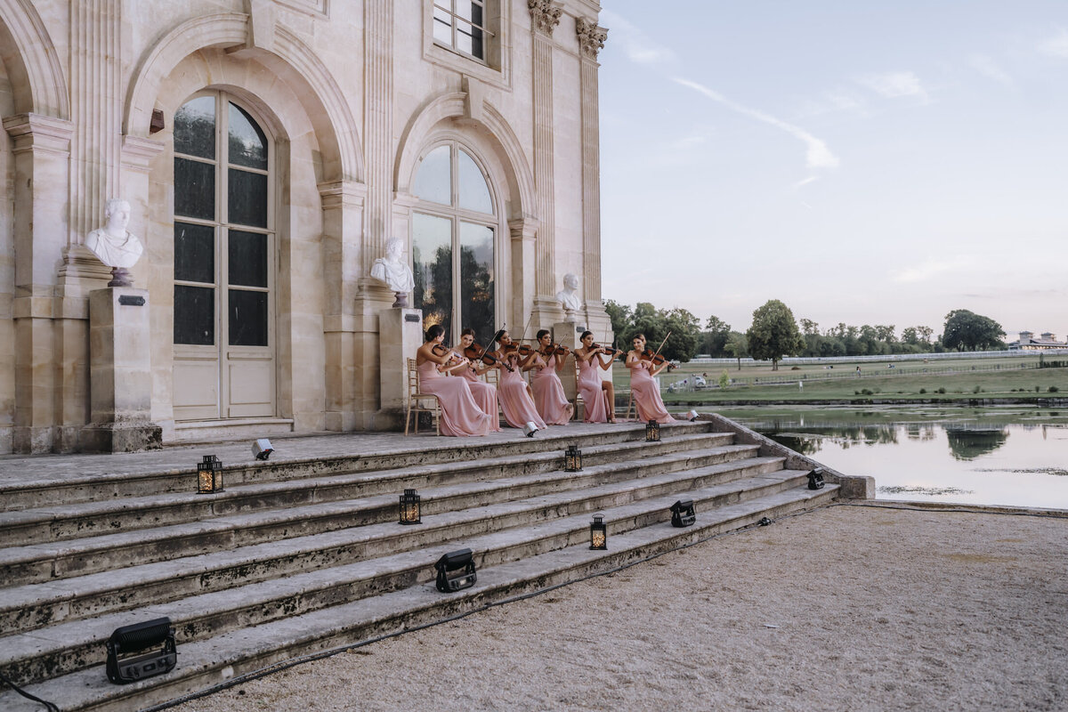Paris Destination Wedding at Chateau de Chantilly by Alejandra Poupel Events horizontal- violonists outside the e-venue 
