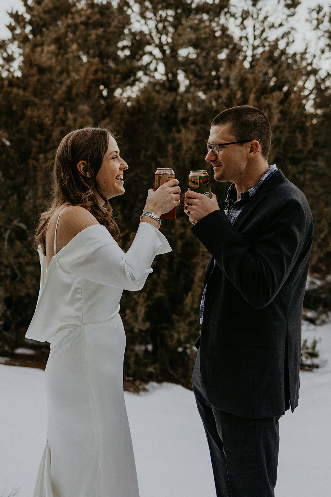 bride and groom enjoying their favorite beer in the snow