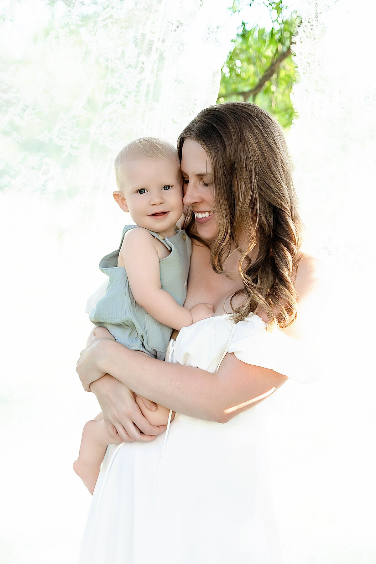 mom snuggling baby closely at seville park