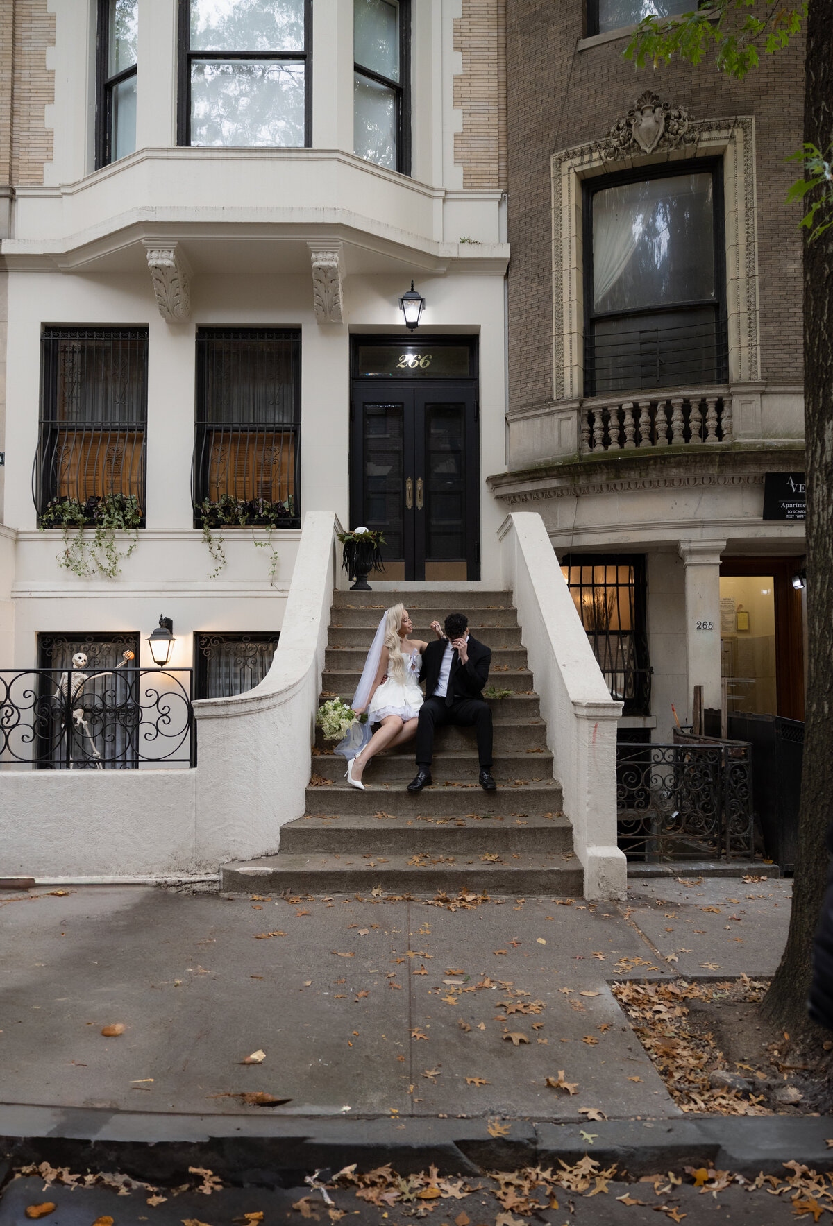 Couple sharing a quiet moment on a NYC step surrounded by city life.