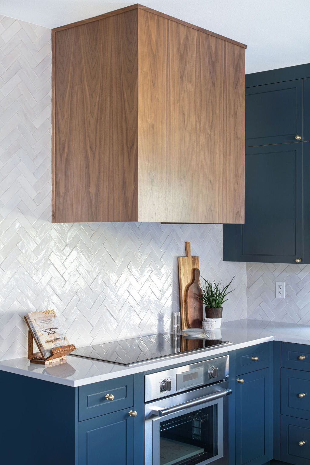 hello-home-austin-contemporary-navy-kitchen-remodel-wood-vent-hood-zelliege-herringbone-backsplash-open-layout-5