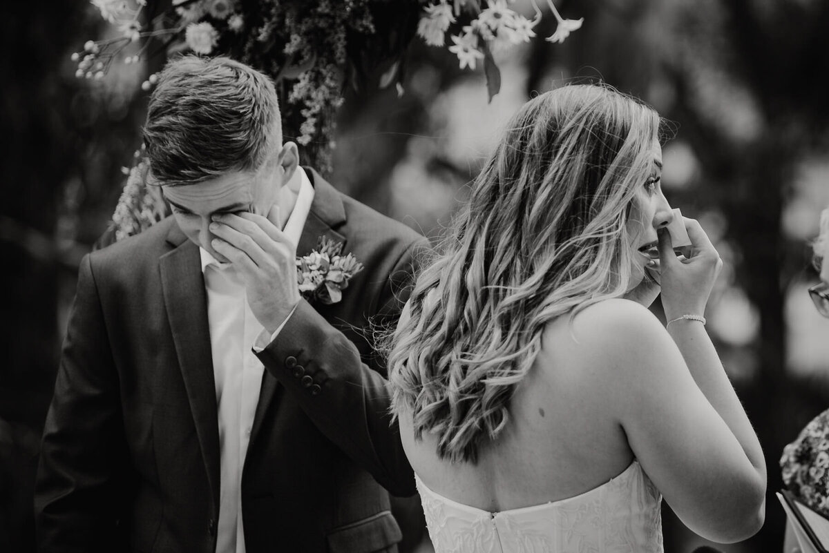 Couple wiping away tears as they reach the top of the aisle at their wedding