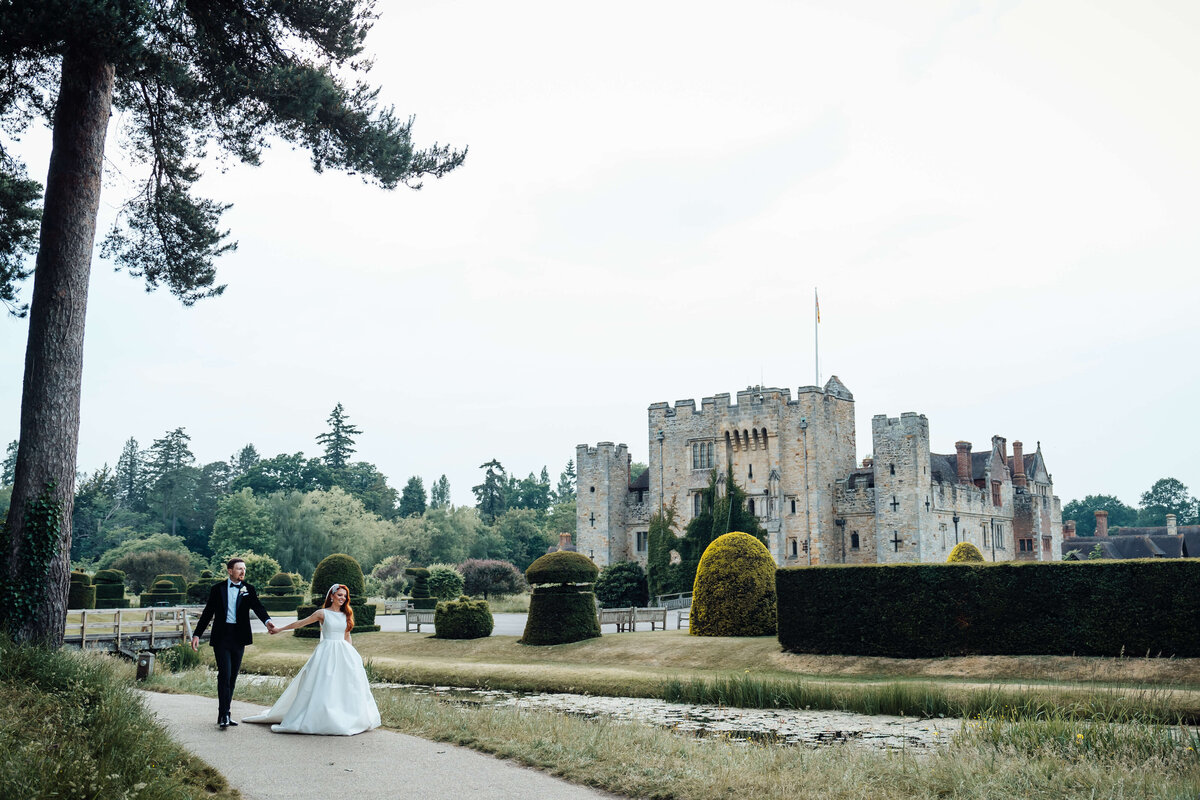 wedding-couple-walking-past-hever-castle-kent-uk