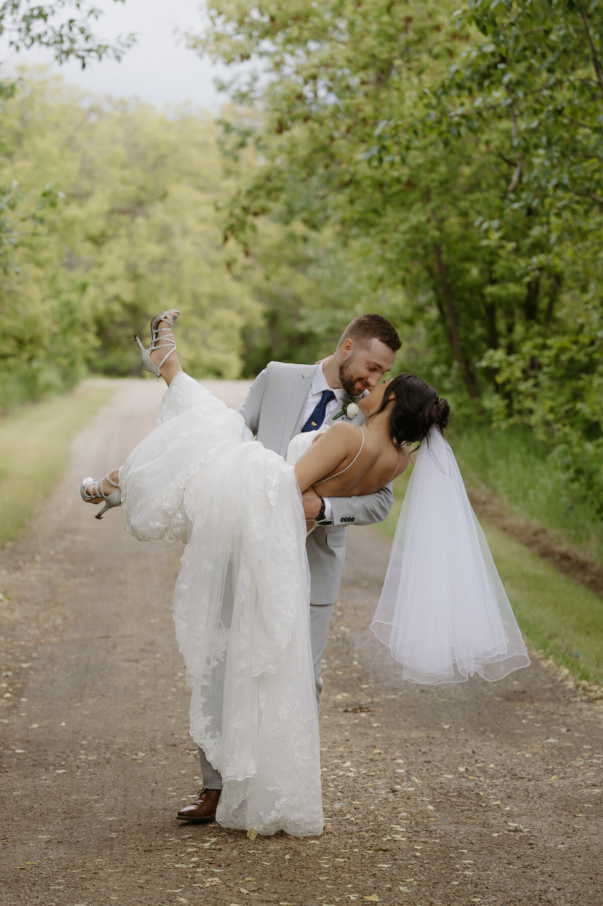 groom carrying bride at alberta wedding