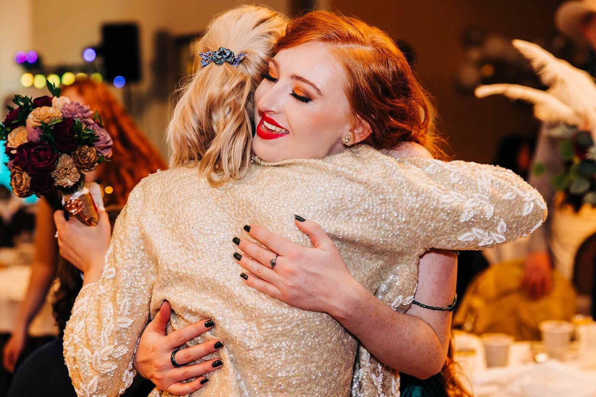 Wedding guests hugging at reception, Broadway River Inn, Hamilton, MT