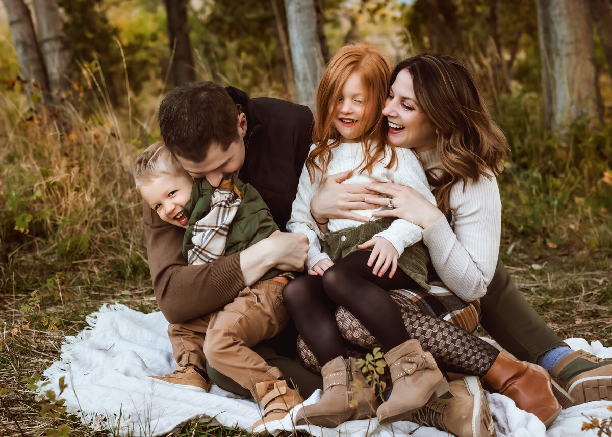 candid family picture in a filed at sunset in the fall in Colorado