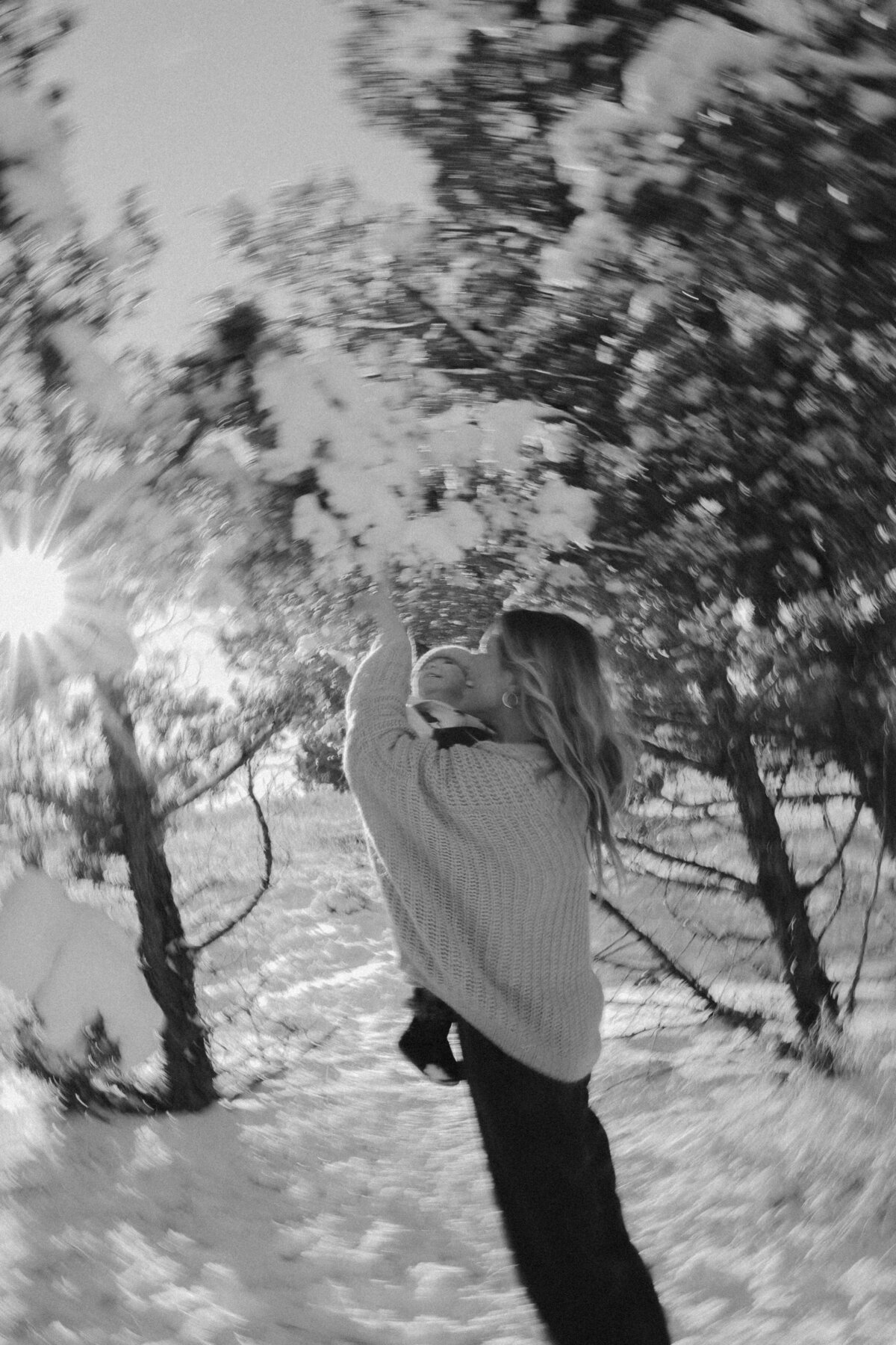Black and White Winter Motherhood Photo with Baby in Snow-Covered Forest