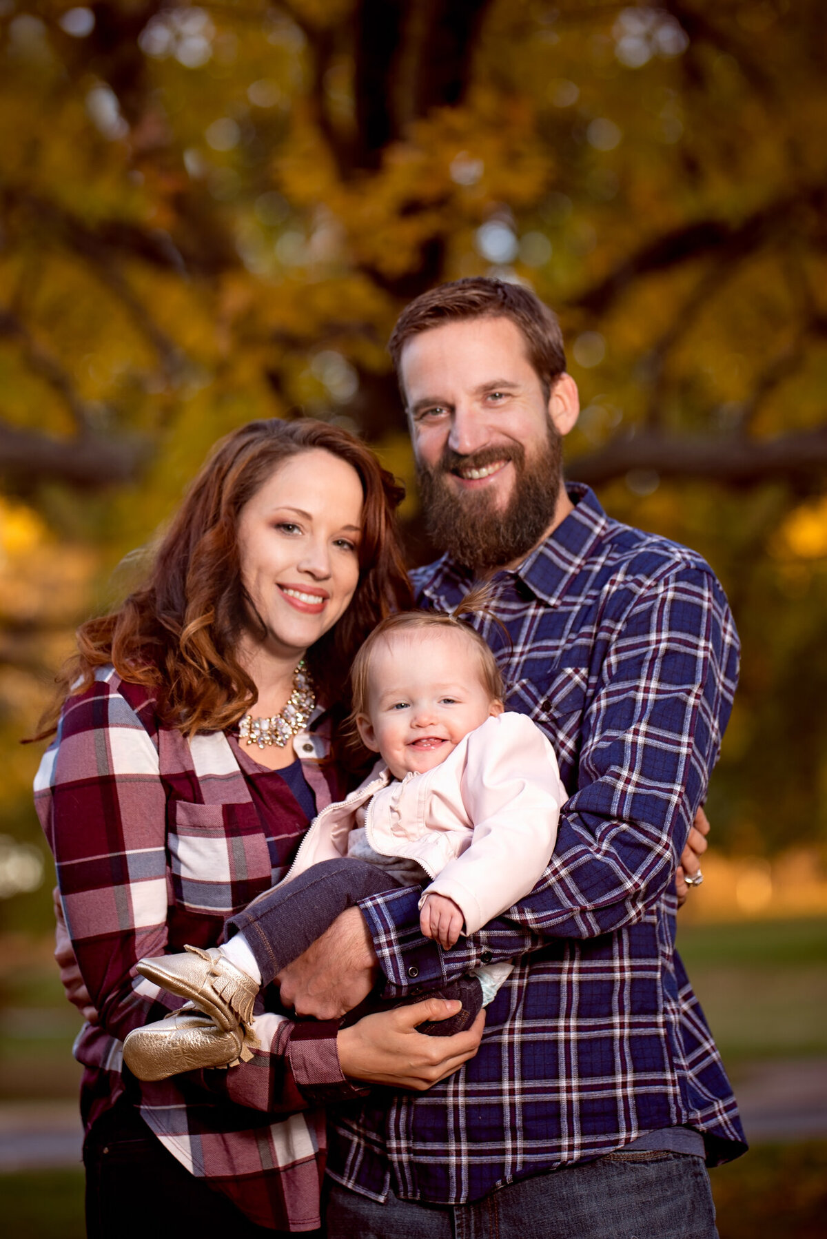 Heartwarming winter family portrait with a fluffy white dog on a cozy blanket, captured in Lenexa, Kansas. A charming option for families seeking pet-friendly family photography in the Kansas City area