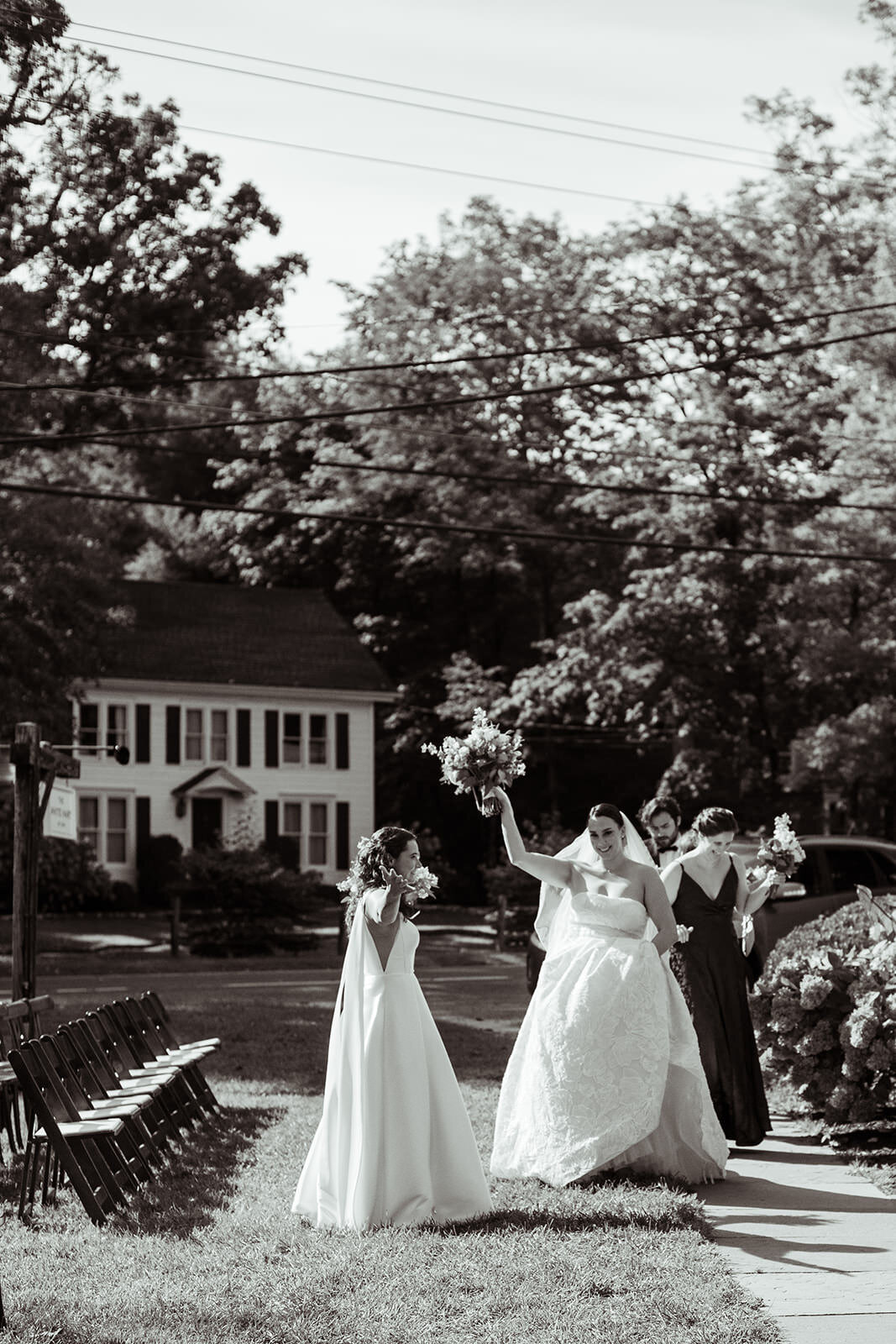 Brides celebrating with hands up after ceremony