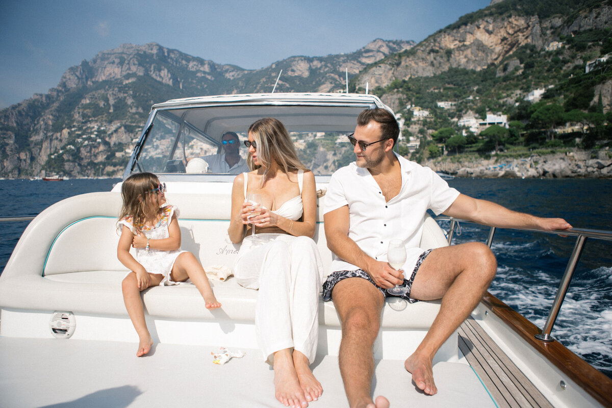 Close-up of bride and groom sharing quiet moment on yacht with colorful Positano view – romantic elopement photography