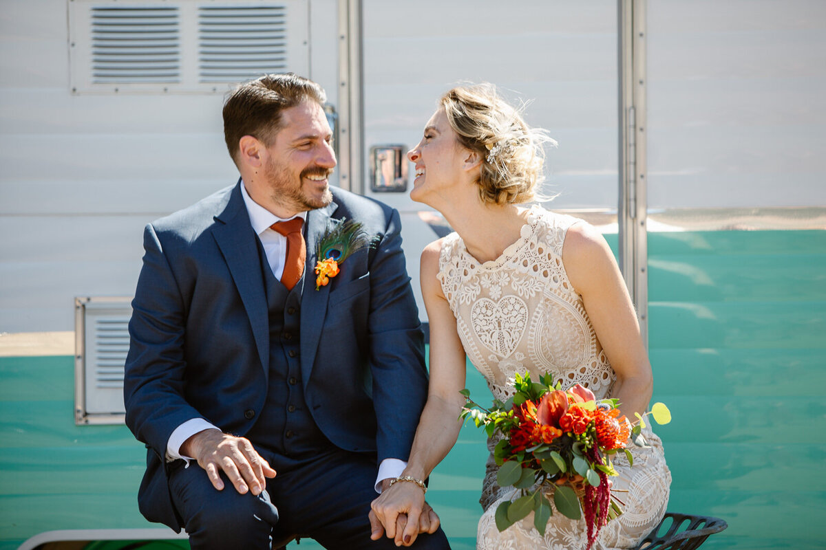 Ali and Brian hold hands and laugh on their wedding day.