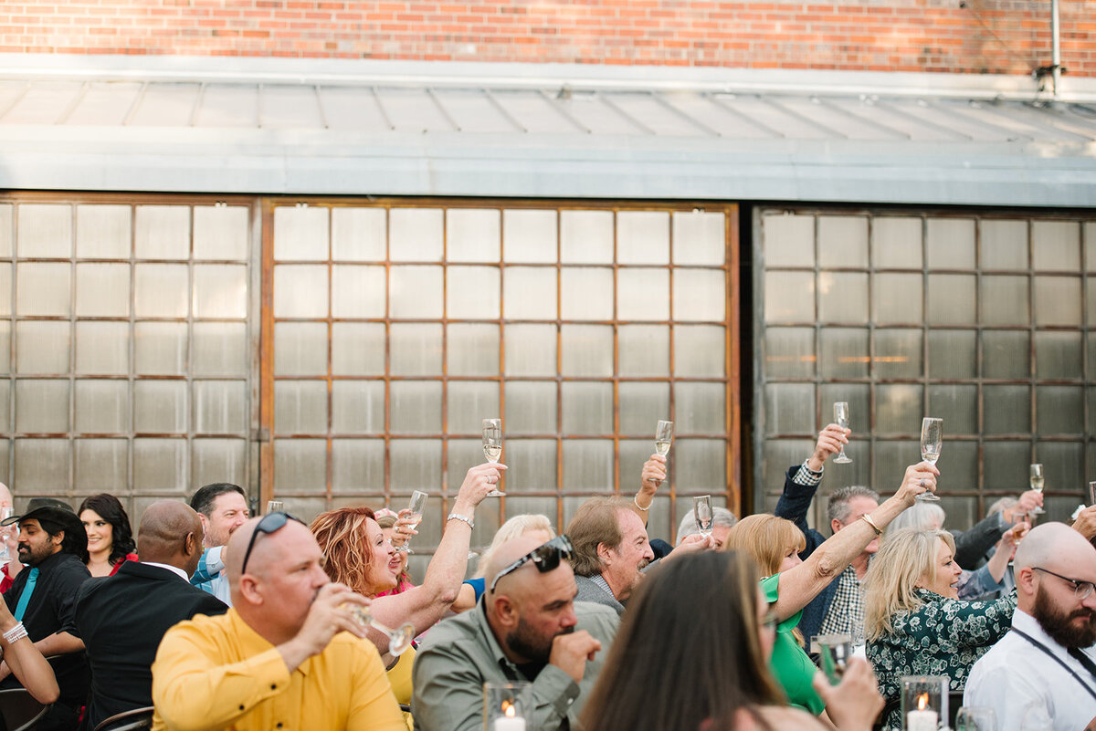 Guests laughing during a heartfelt toast at a Denver wedding reception, captured in an unposed, documentary style.
