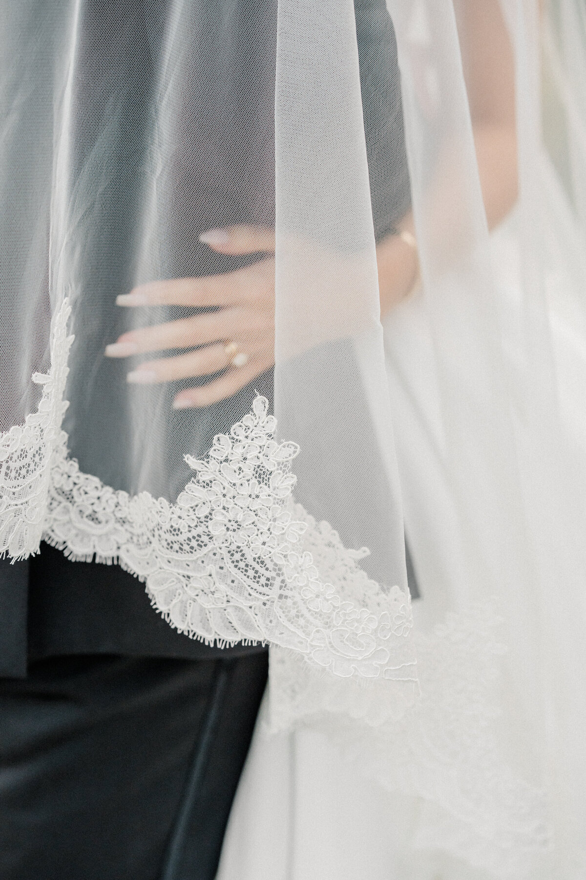 Romantic wedding moment at The Estate at River Run, featuring a bride and groom embracing beneath a delicate lace-edged veil. Captured by Caitlin Wilcox Photography, a Richmond, VA film wedding photographer