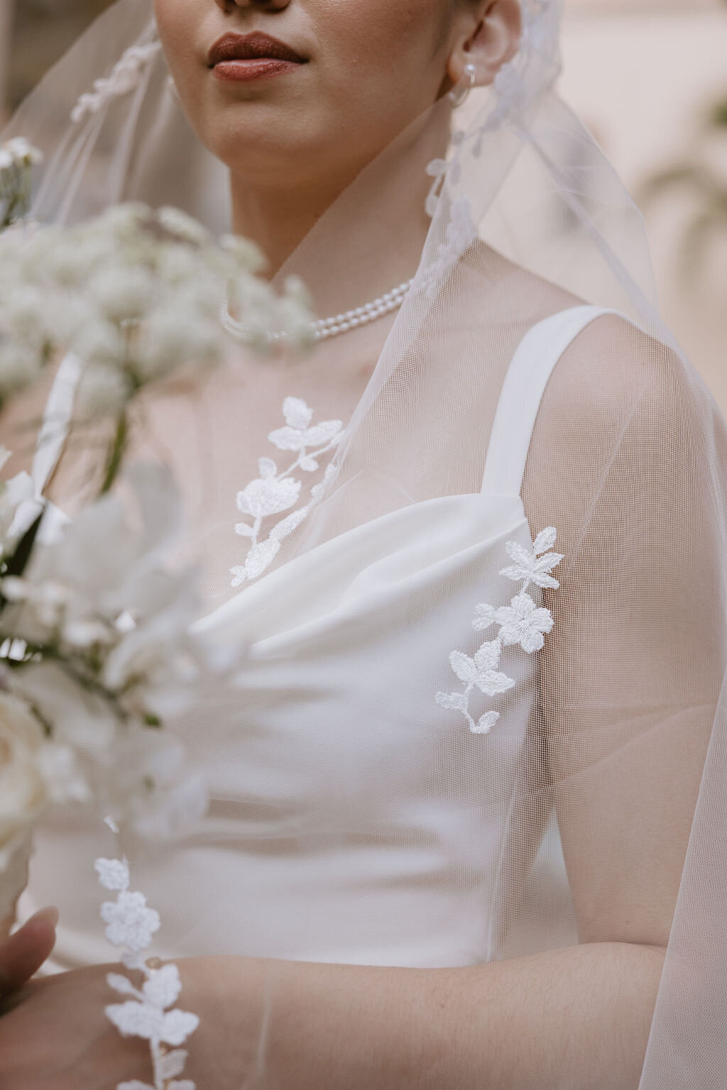 close up of brides veil, dress and flowers