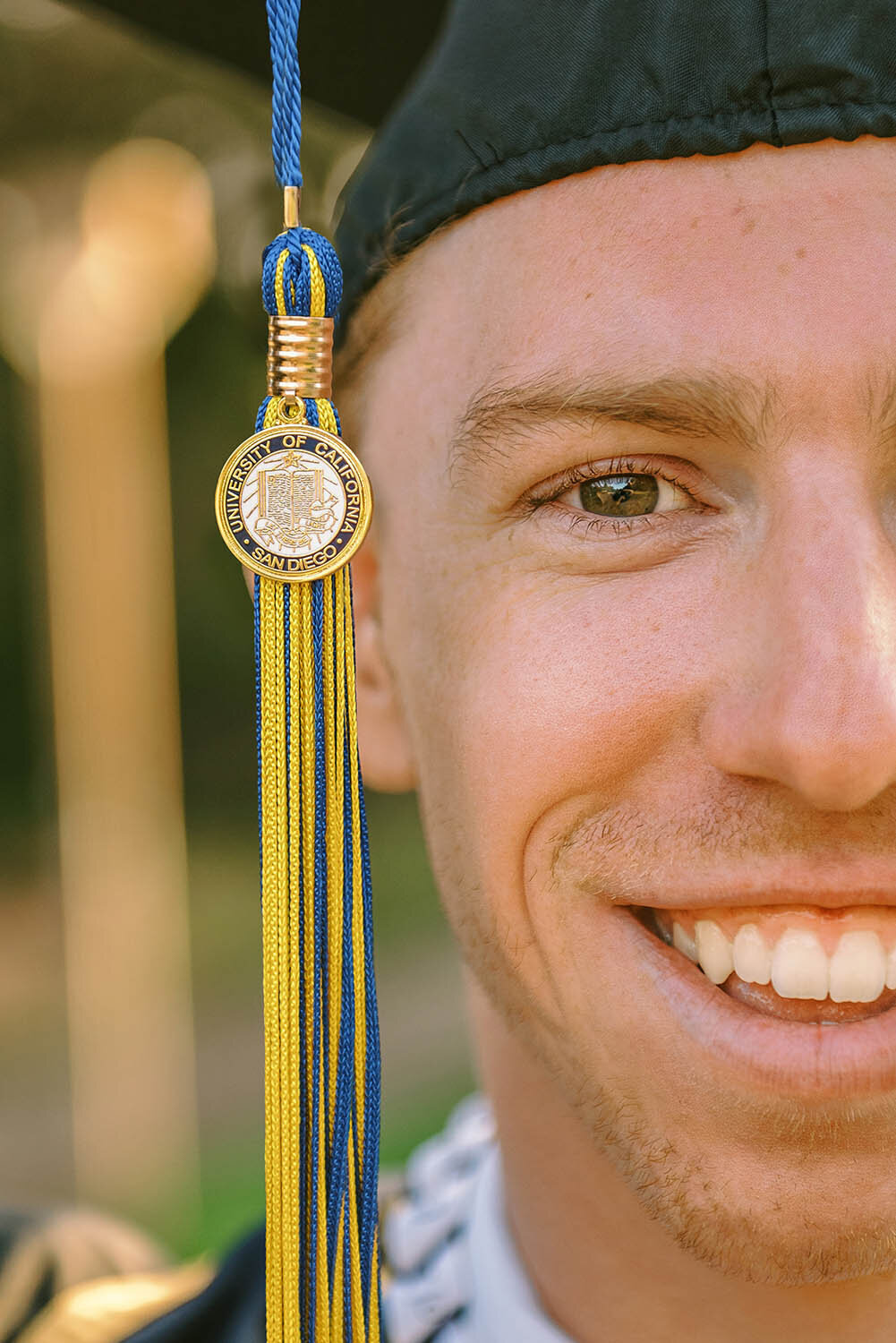 Closeup portrait of a graduate's face and his tassel