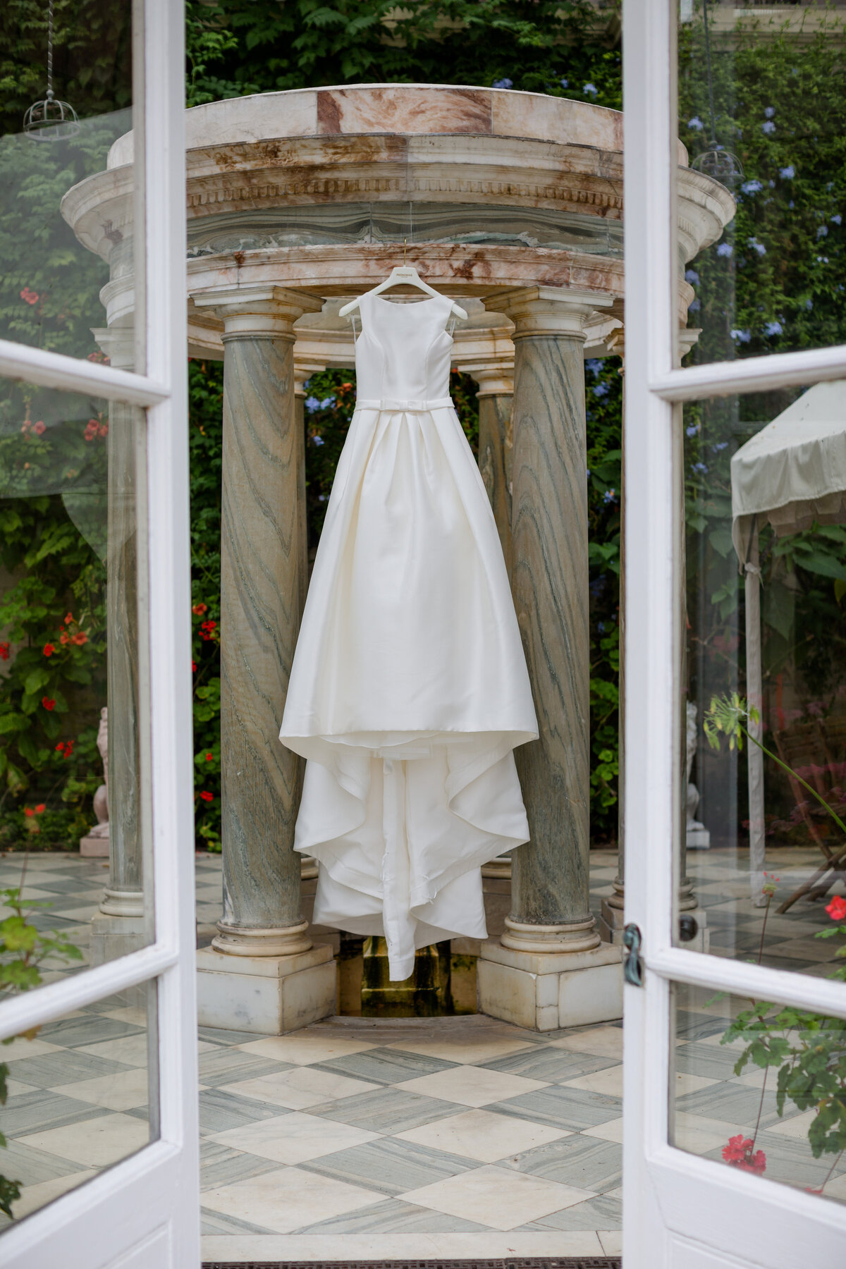 A Pronovias Wedding Dress hanging in a doorway