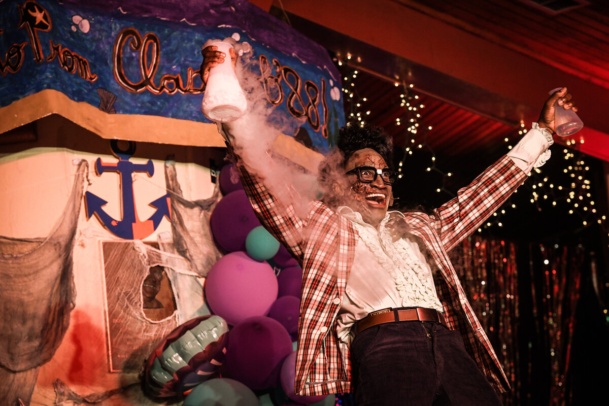 A person in a theater costume celebrating