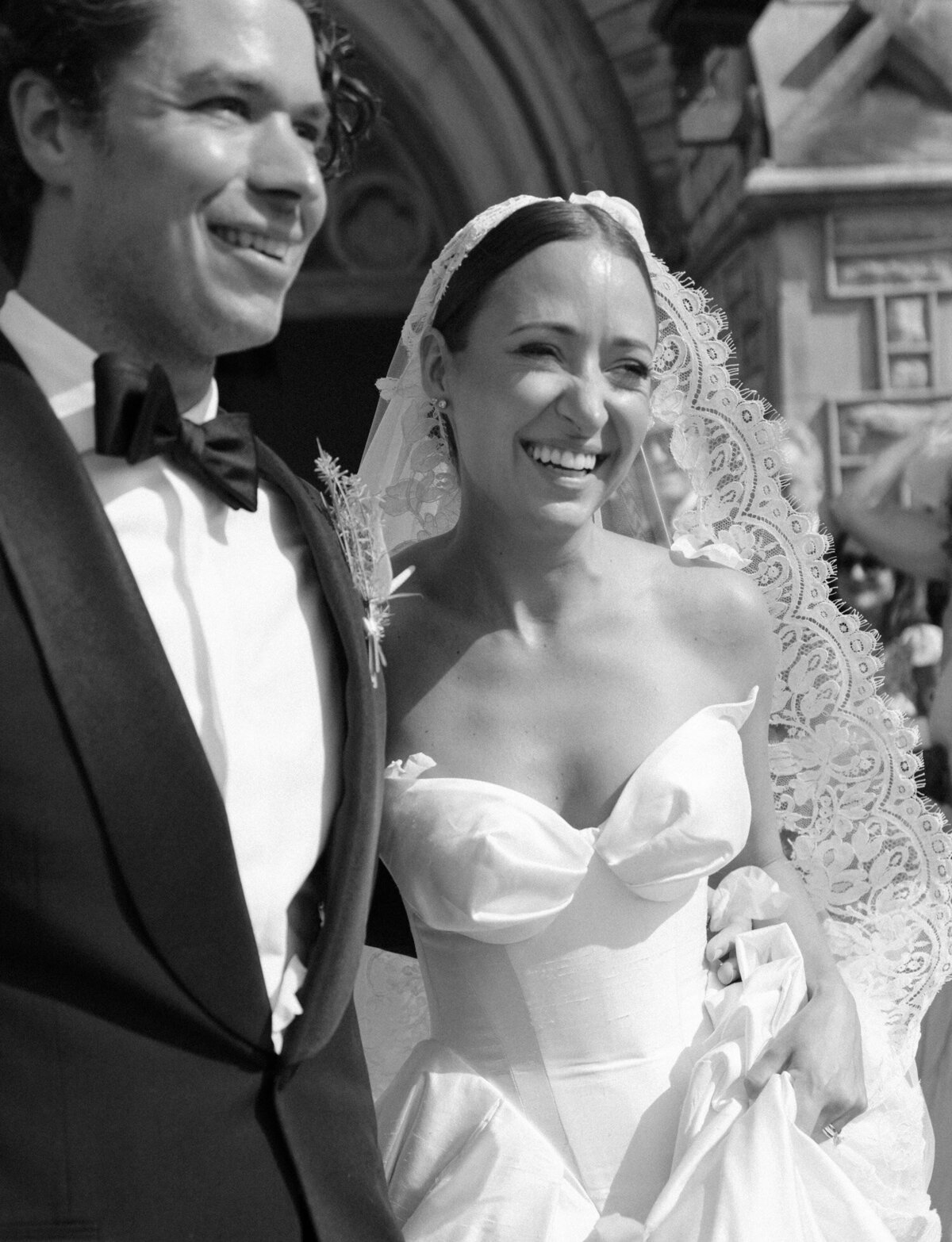 newlywed couple laughs during their Detroit wedding petal toss outside Christ Church
