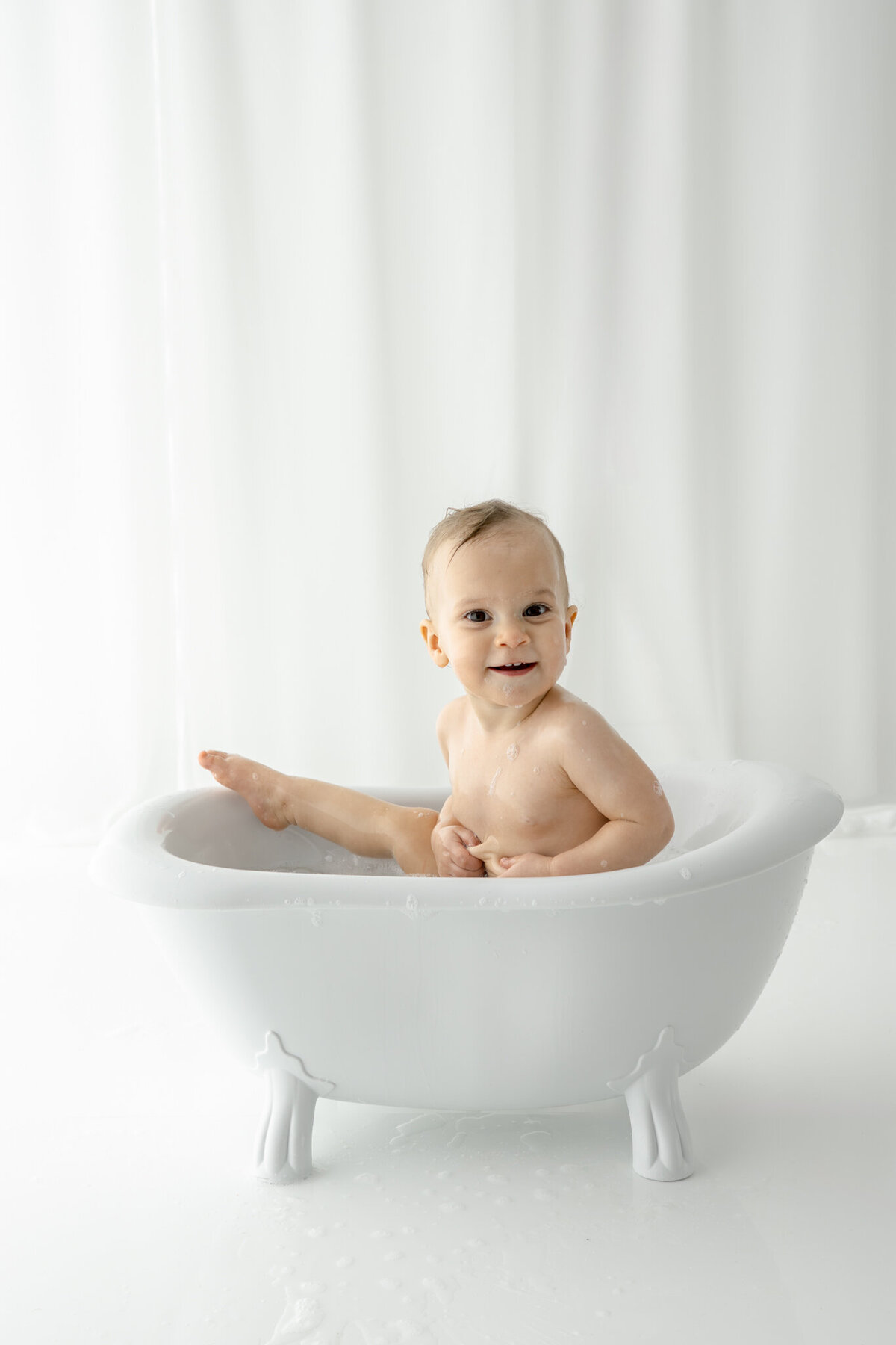 Girl getting bubblebath following cake smash during themed cake smash session— captured by Alliston and Barrie cake smash photographer.