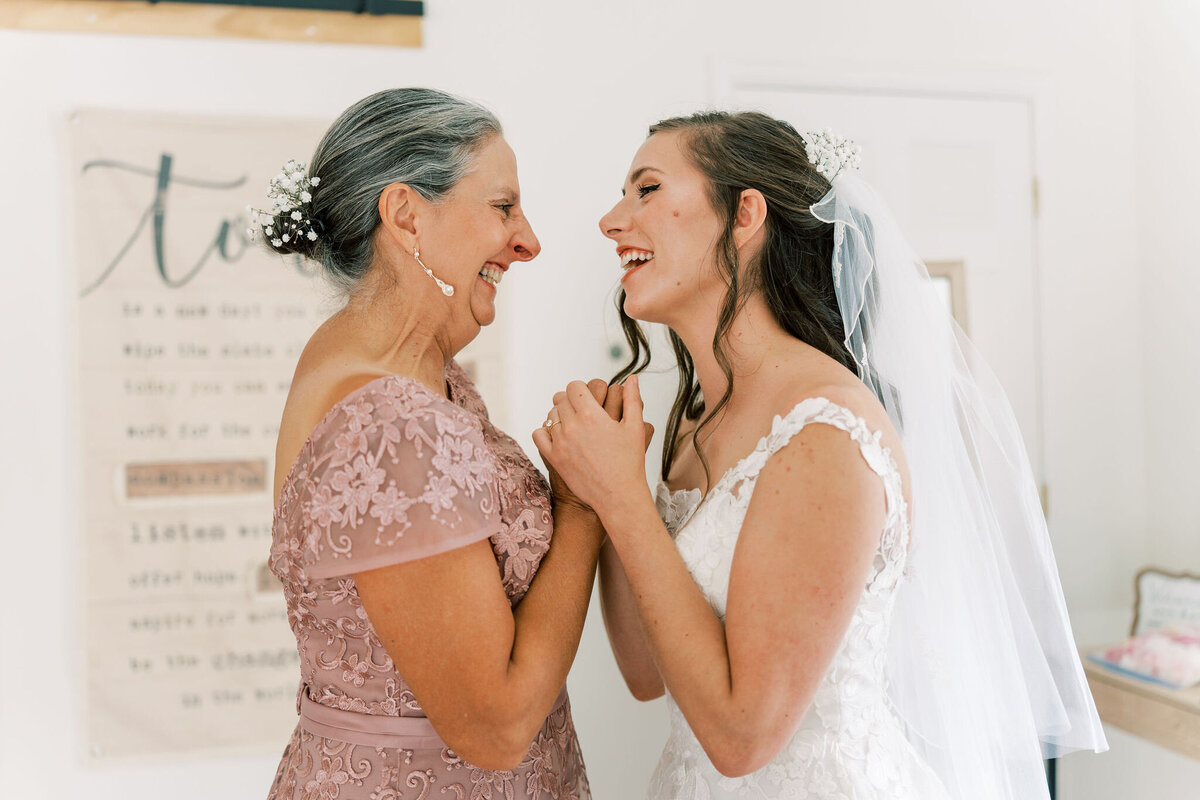 mother and daughter hold hands on wedding day
