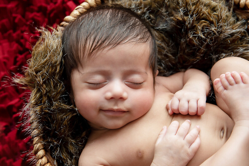 baby boy smiling for his newborn photos in Hamilton, Ontario.