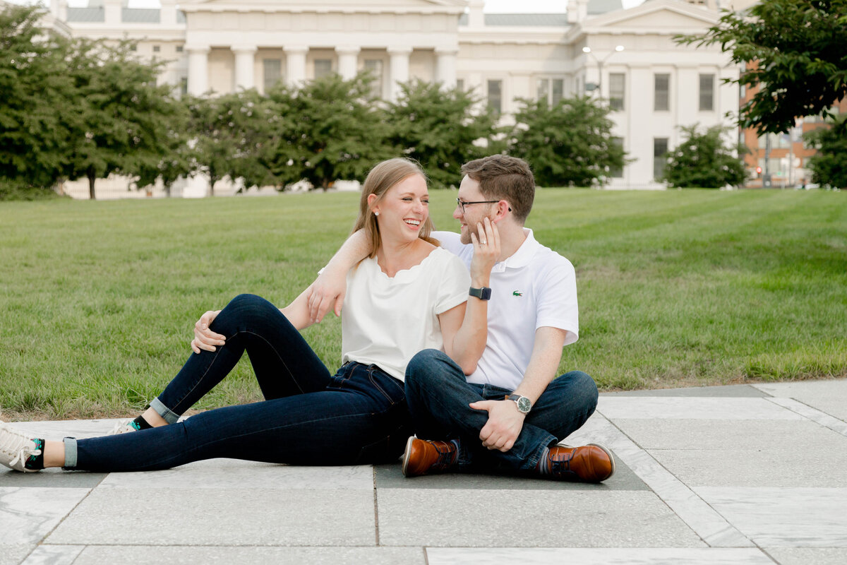 Scenic engagement photo captured by Style & Grace Photography at Keiner Plaza in St. Louis, featuring the couple with the iconic STL Arch and fairgrounds in the background.