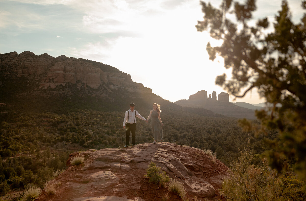 Couple standing against red rock backdrop during Sedona engagement session