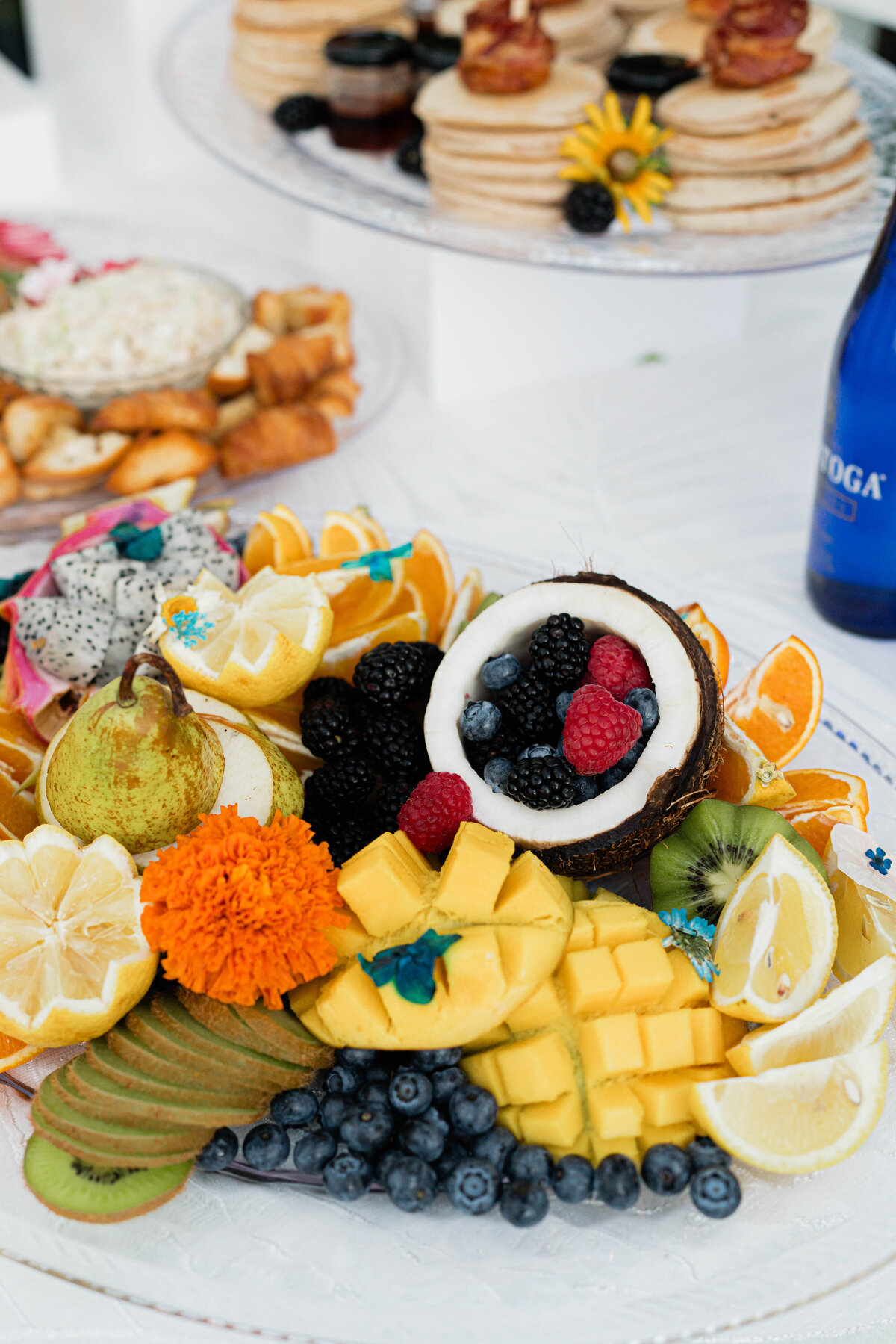 fruit charcuterie of sliced kiwi, cubed mango, coconut, strawberries, dragonfruit, pears, oranges and blueberries