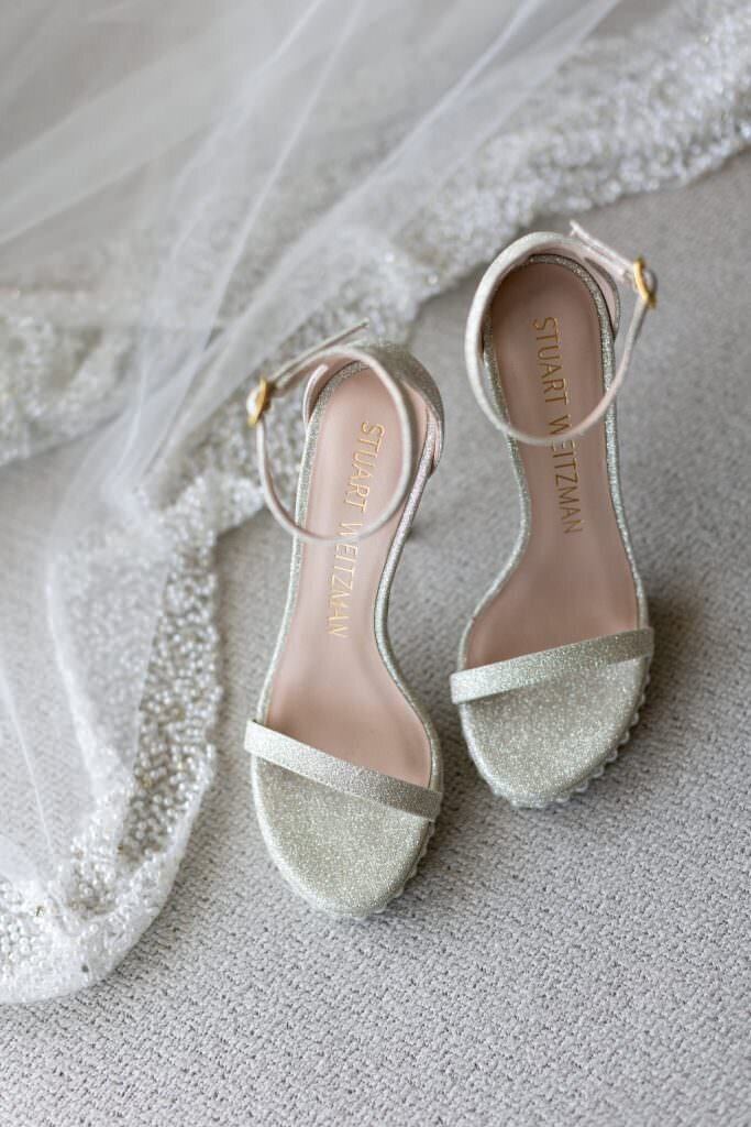 White heels with a veil laying next to them