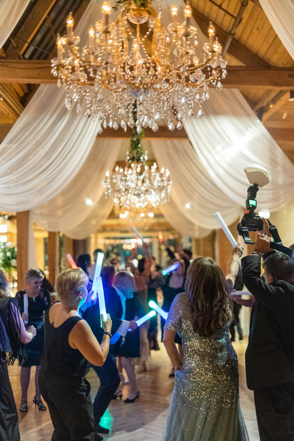 A group of people holding light sticks in a room