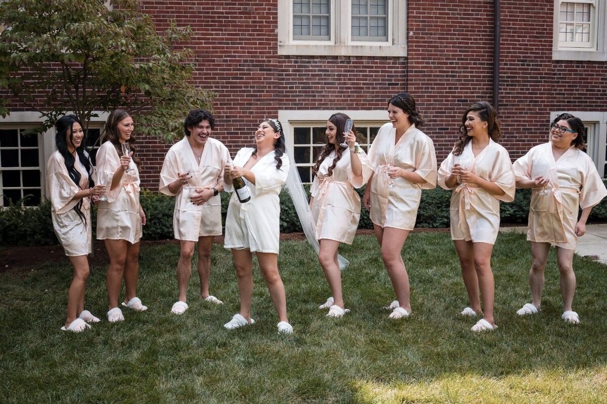 Bride sharing a joyful moment with bridesmaids outside Union Club Hotel