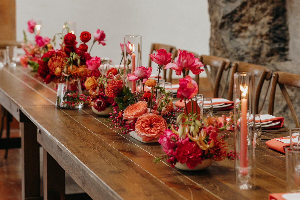 Small modern floral arrangements on long reception tables