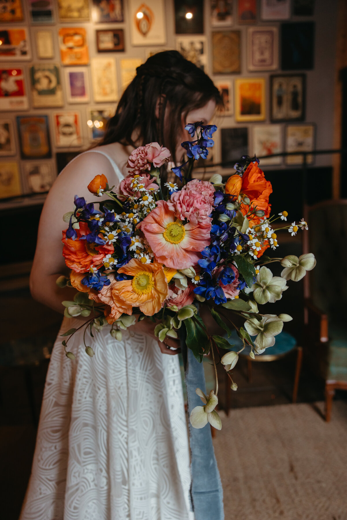 bride holds colorful bouquet in front of face