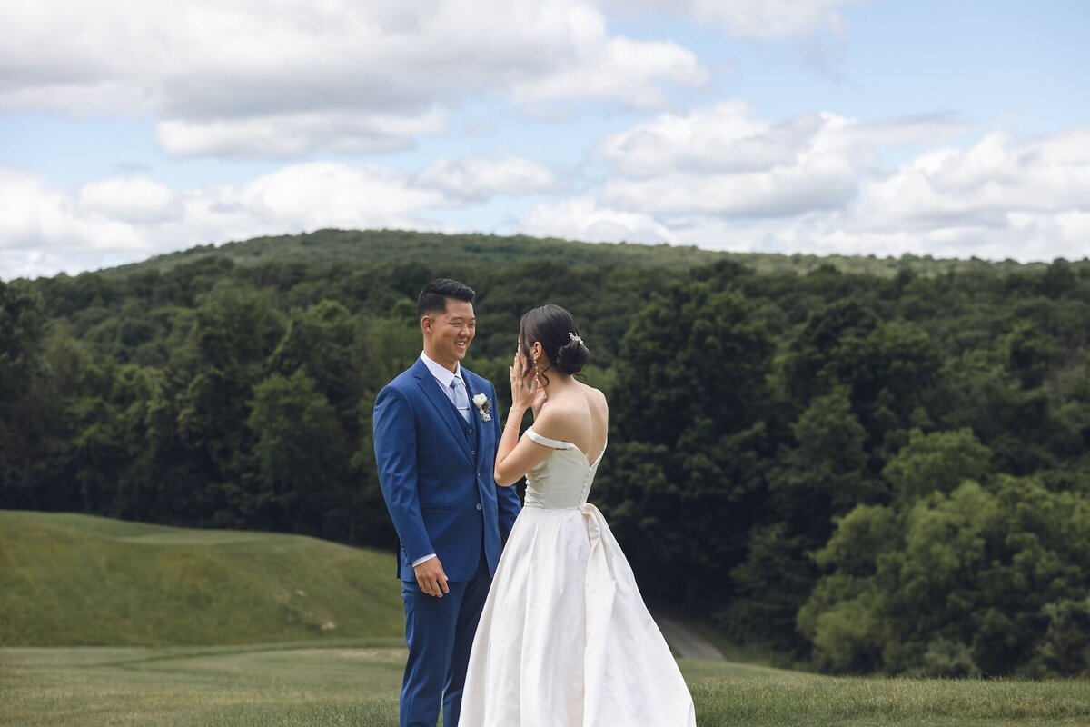 Bride and groom smiling at each other during first look