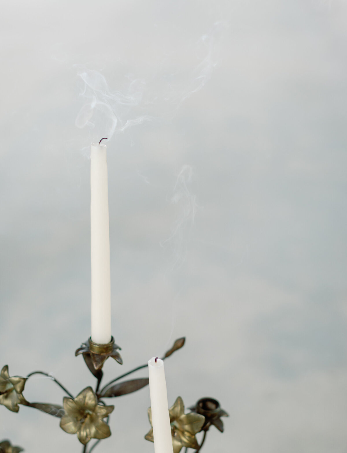 blown out candle smoke rises, ornate brass candelabra at Greece ruins wedding venue
