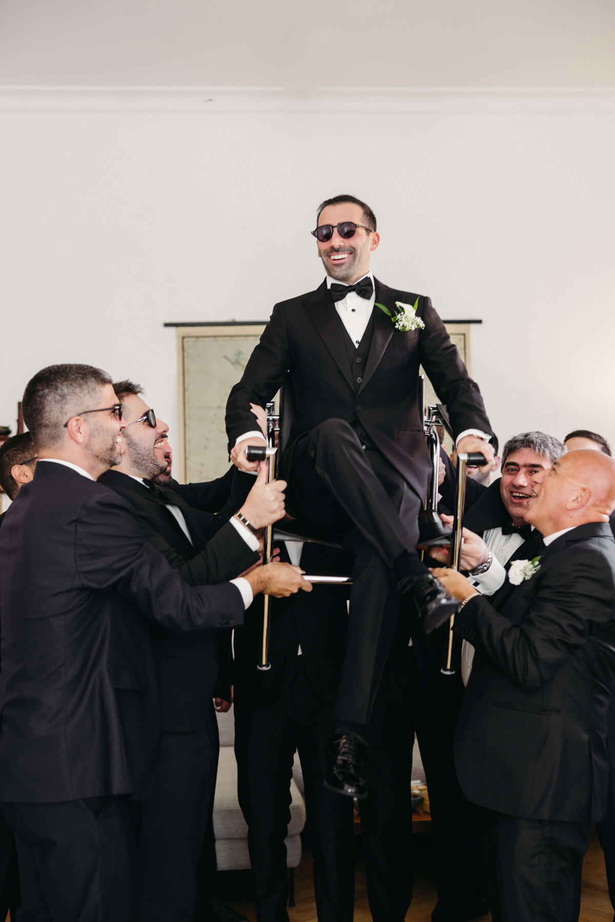 Groomsmen lifting groom in celebratory moment before wedding
