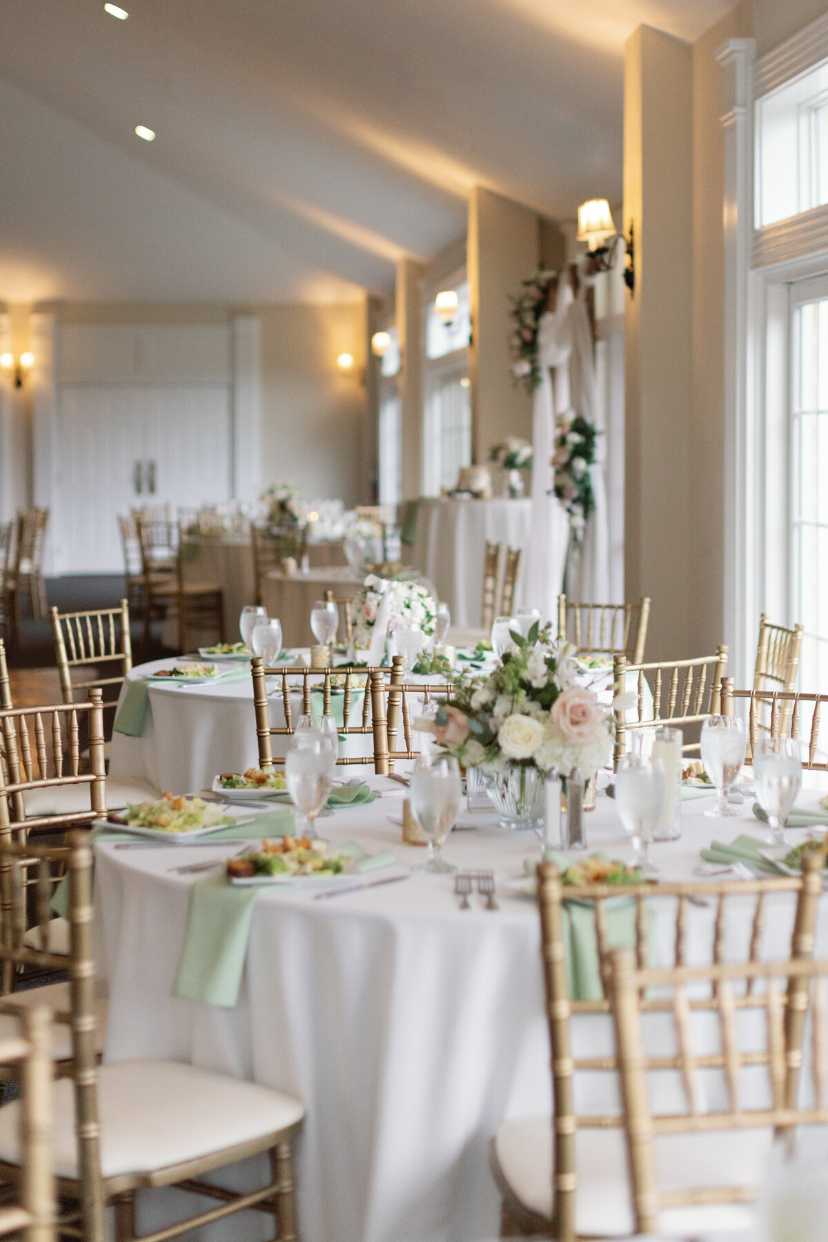 Reception tables with gold chiavari chairs, greenery accents, and floral centerpieces at Springfield Manor.