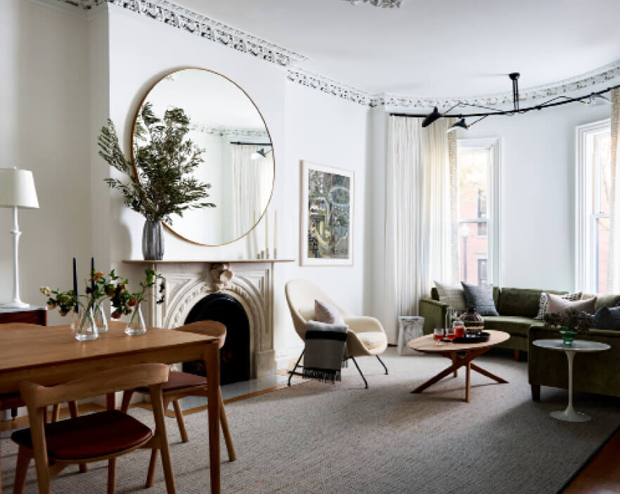 Boston Interior Designers designed a mixed living and dining room with modern and mid-century furniture, original plaster ceiling details, and historic brownstone design.