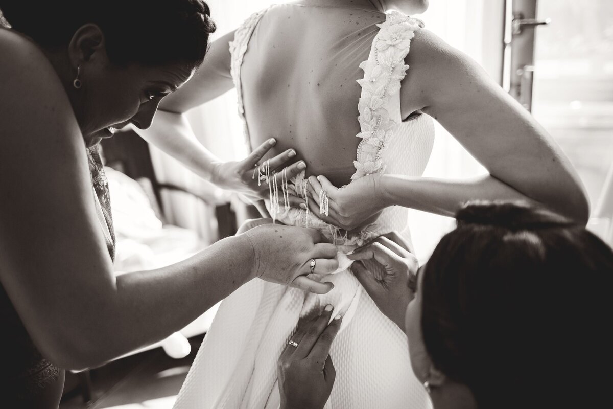 Bride getting final touches of dress put on at wedding in Riviera Maya