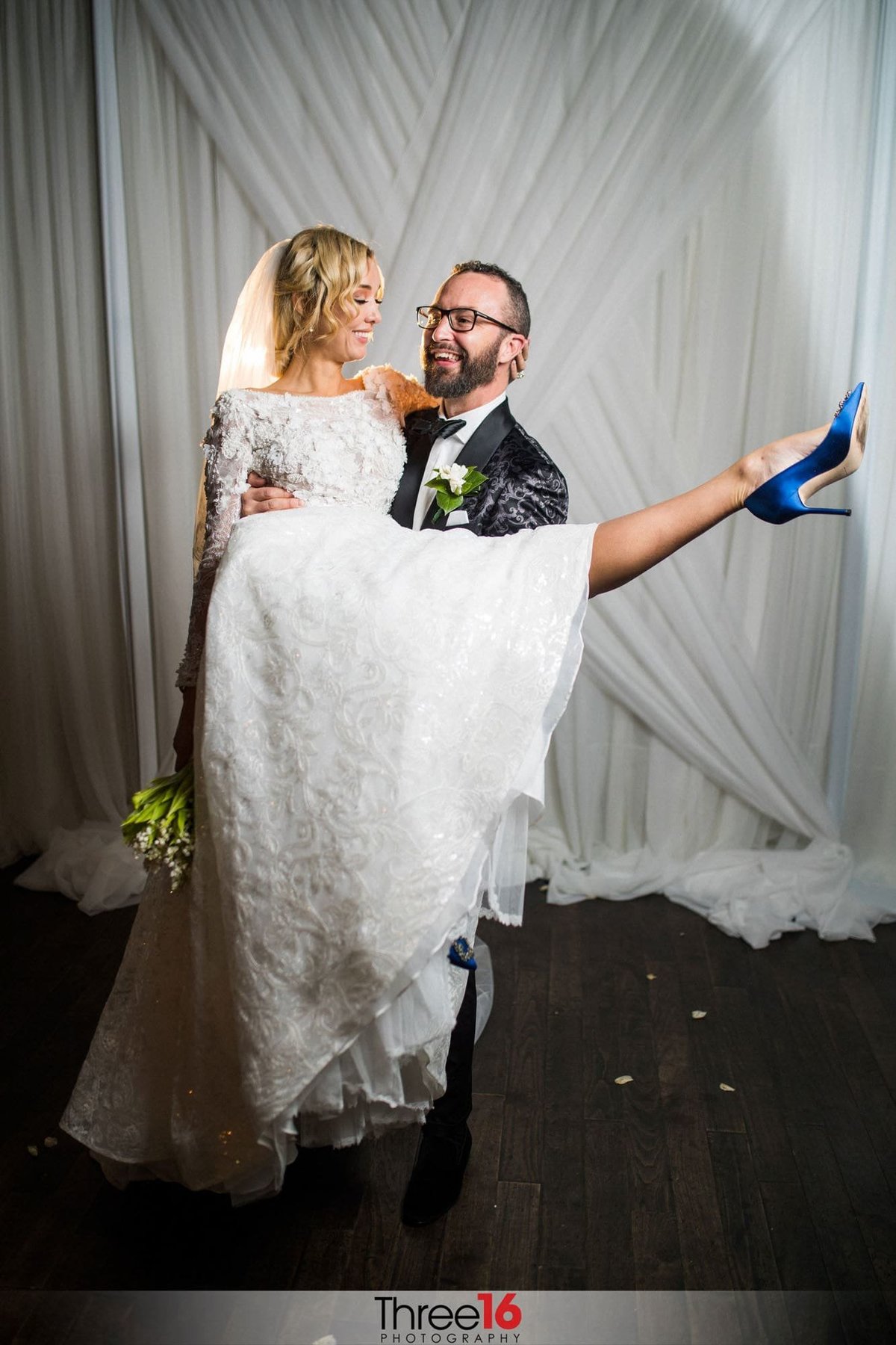 Groom carries his Bride as she kicks up her heels