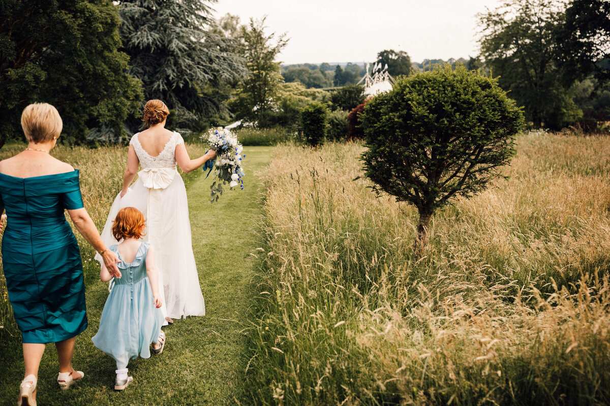 Countryside wedding women walking through field to ceremony