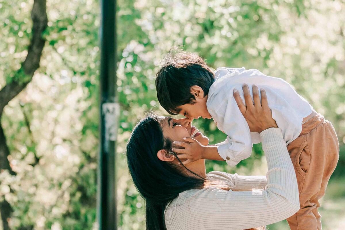Mom holding son and putting foreheads together. 