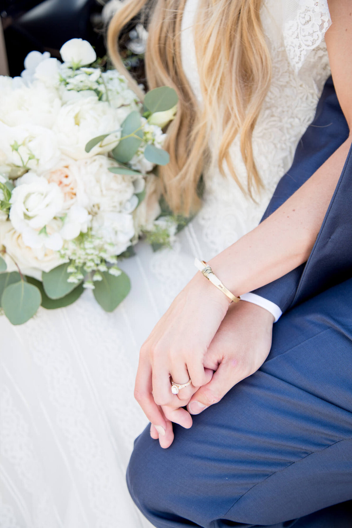 a wedding couple holding hands on their beautiful bright wedding day