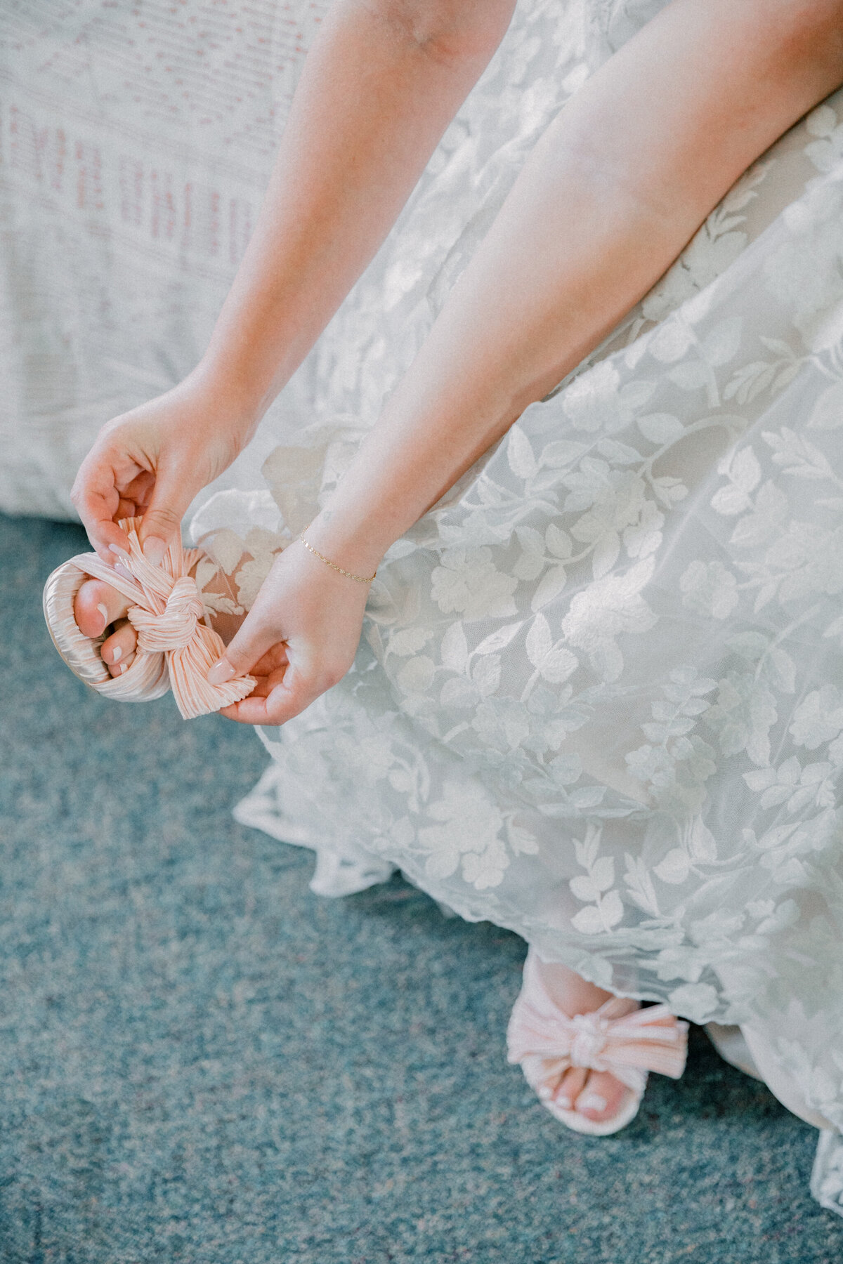 Three Oaks Manor Wedding | bride put on pink shoe with bow