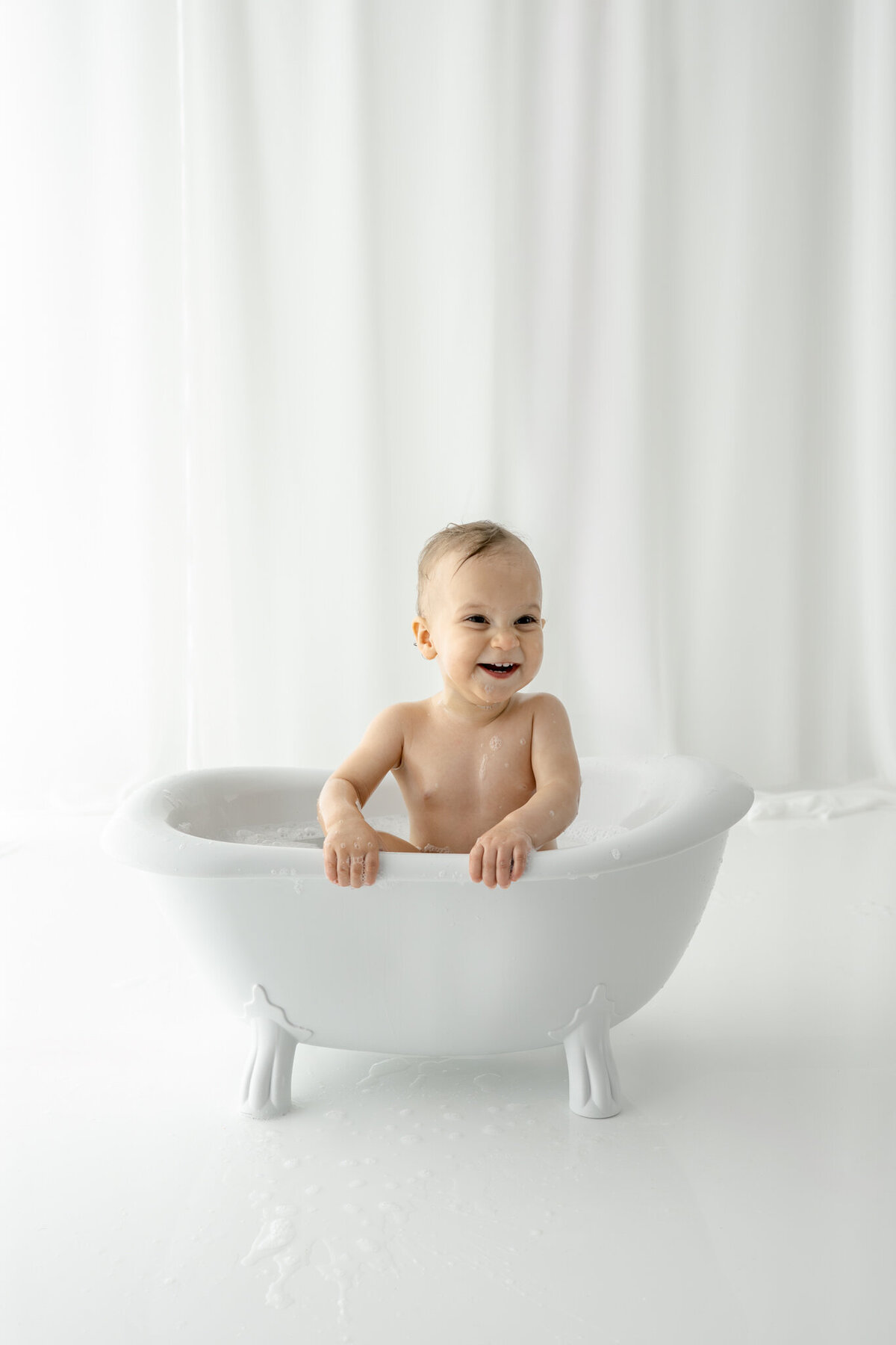 Girl getting bubblebath following cake smash during themed cake smash session— captured by Alliston and Barrie cake smash photographer.