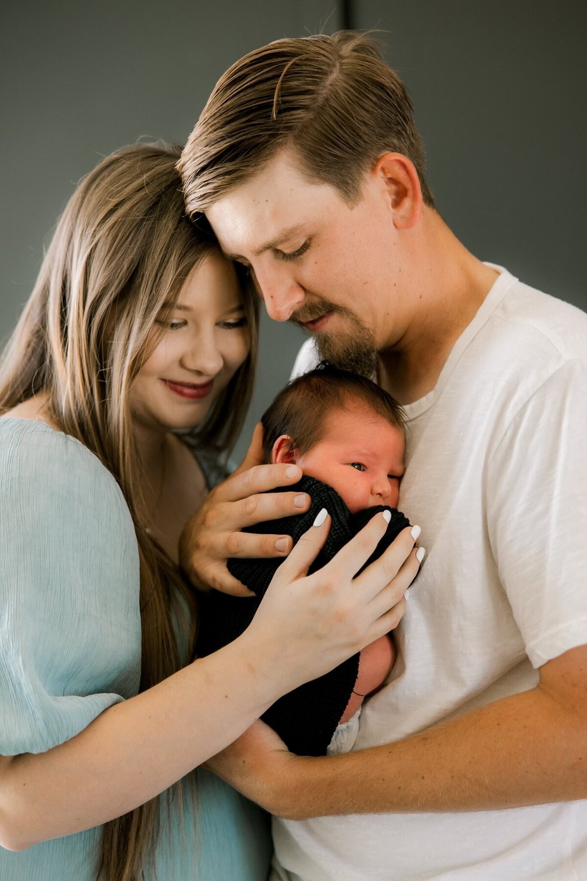 first time parents cuddling their newborn